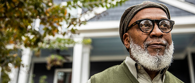 an african american man standing outside his home